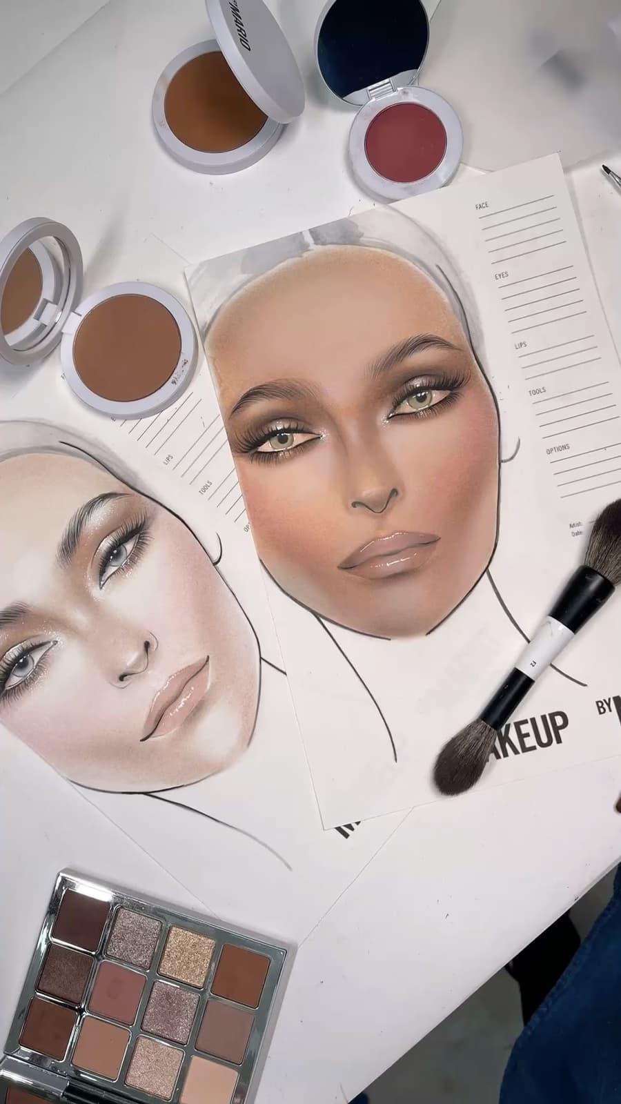 Professional makeup face charts and products laid out during a makeup artist mentorship session with Elani Artistry Dubai