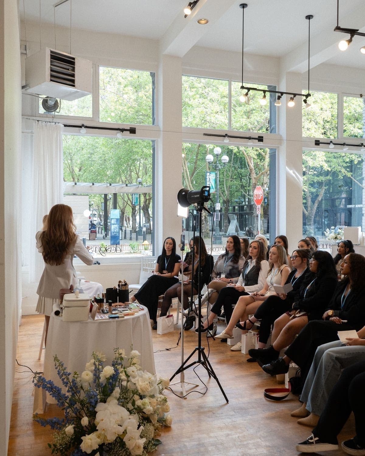 Makeup artist presenting to a seated audience at a professional mentorship masterclass, Elani Artistry Dubai