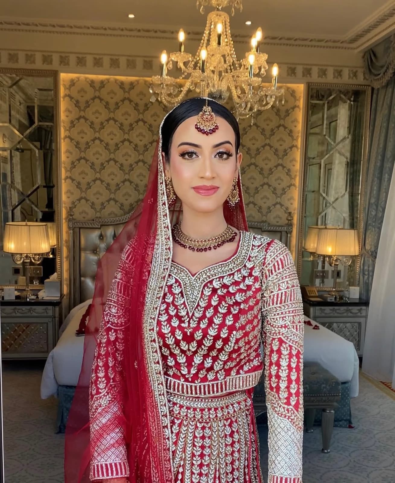 Punjabi Pakistani bride in Dubai with bold vibrant bridal makeup in red and gold lehenga with traditional jewellery by Elani Artistry