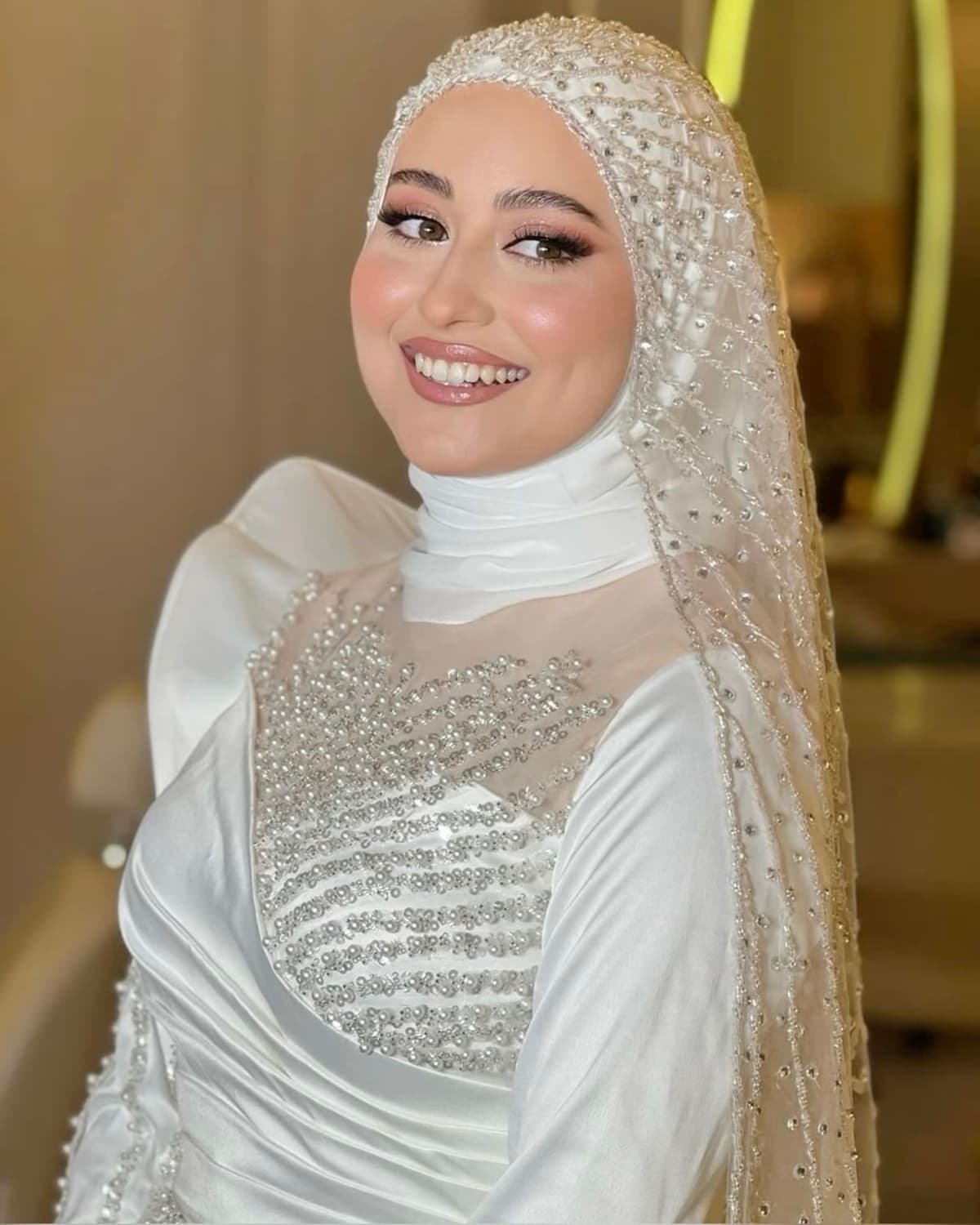 Hijabi bride with beaded veil smiling, specialist Arabic bridal makeup by Elani Artistry Dubai