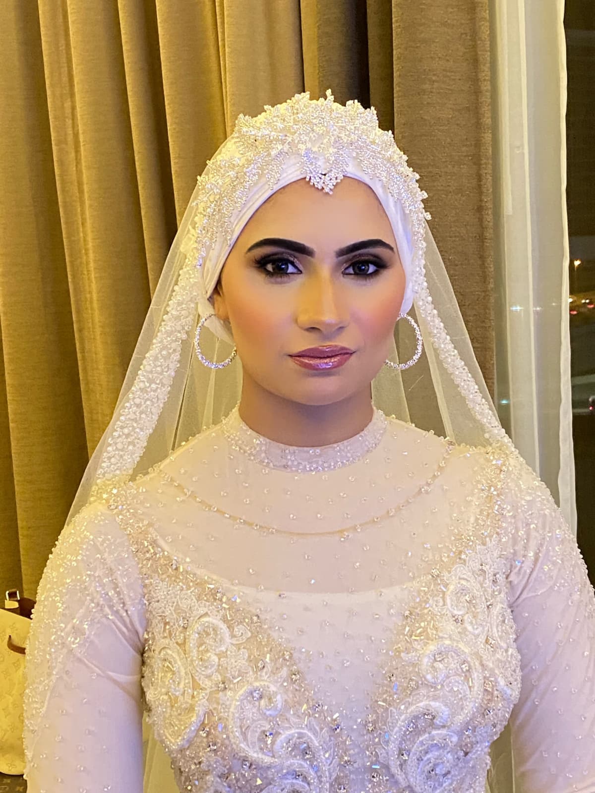 Hijabi Muslim bride in Sharjah with elegant modest bridal makeup radiant skin defined brows and refined lip finish complementing hijab by Elani Artistry