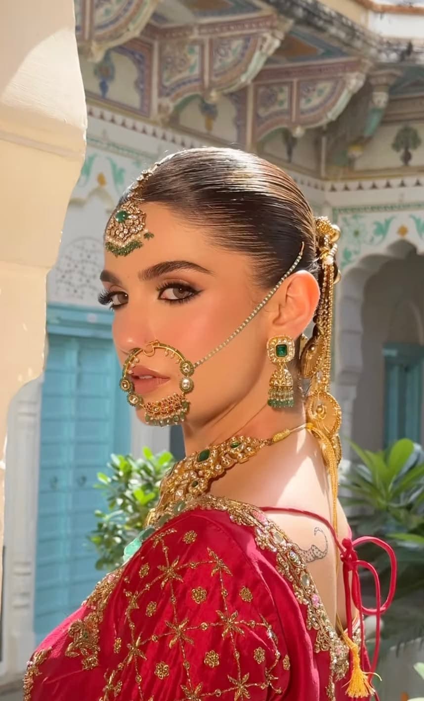 Kashmiri bride with nath, maang tikka and gold jewellery, refined bridal makeup by Elani Artistry Dubai
