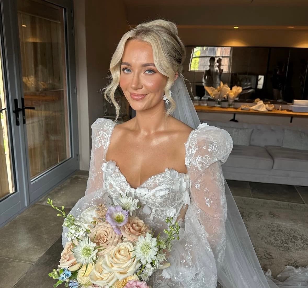 South African and Australian bride in Abu Dhabi with bronzed glowing skin, soft bridal updo and pastel bouquet by Elani Artistry