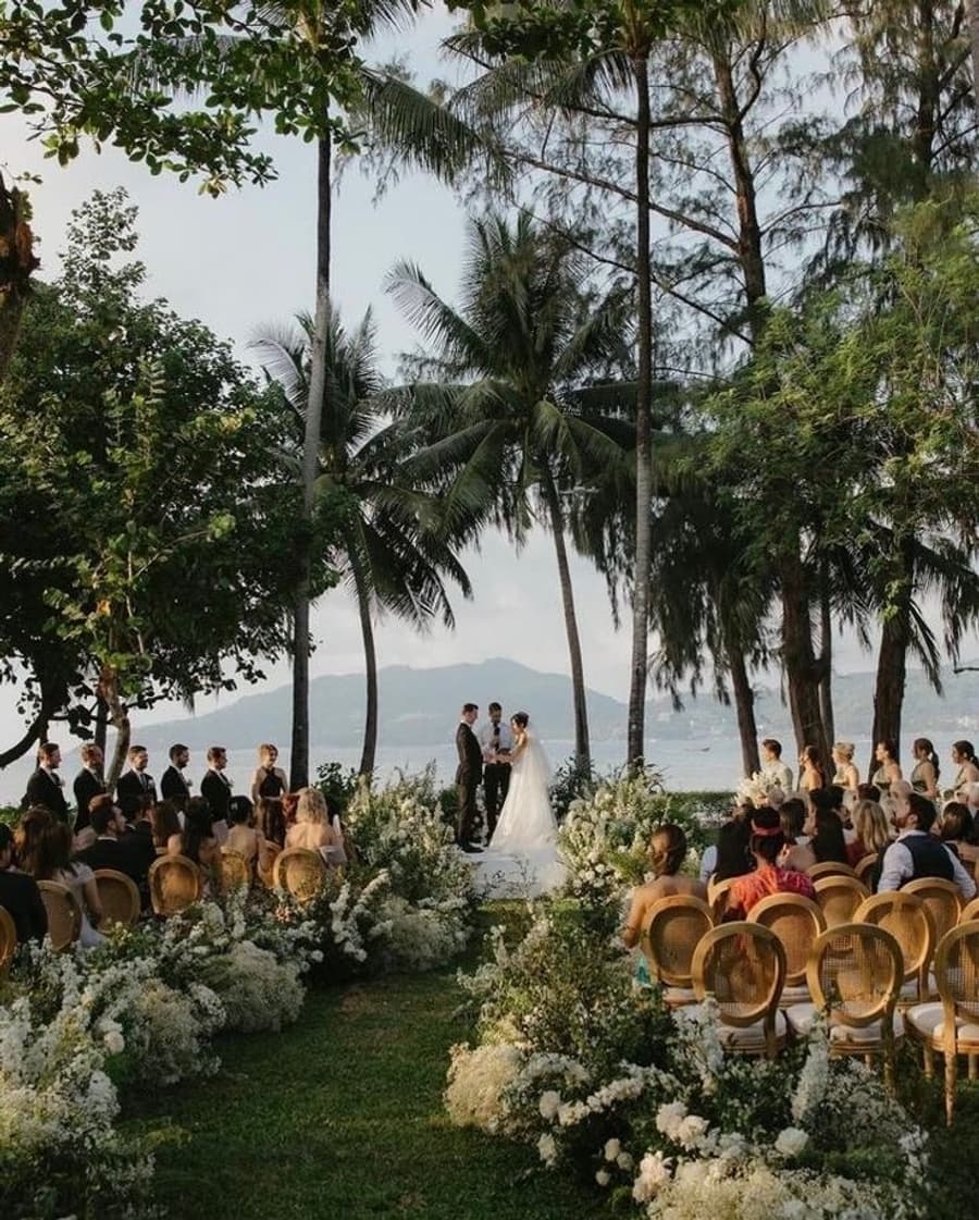 Outdoor wedding ceremony under palm trees with ocean view in Phuket Thailand, destination bridal makeup by Elani Artistry