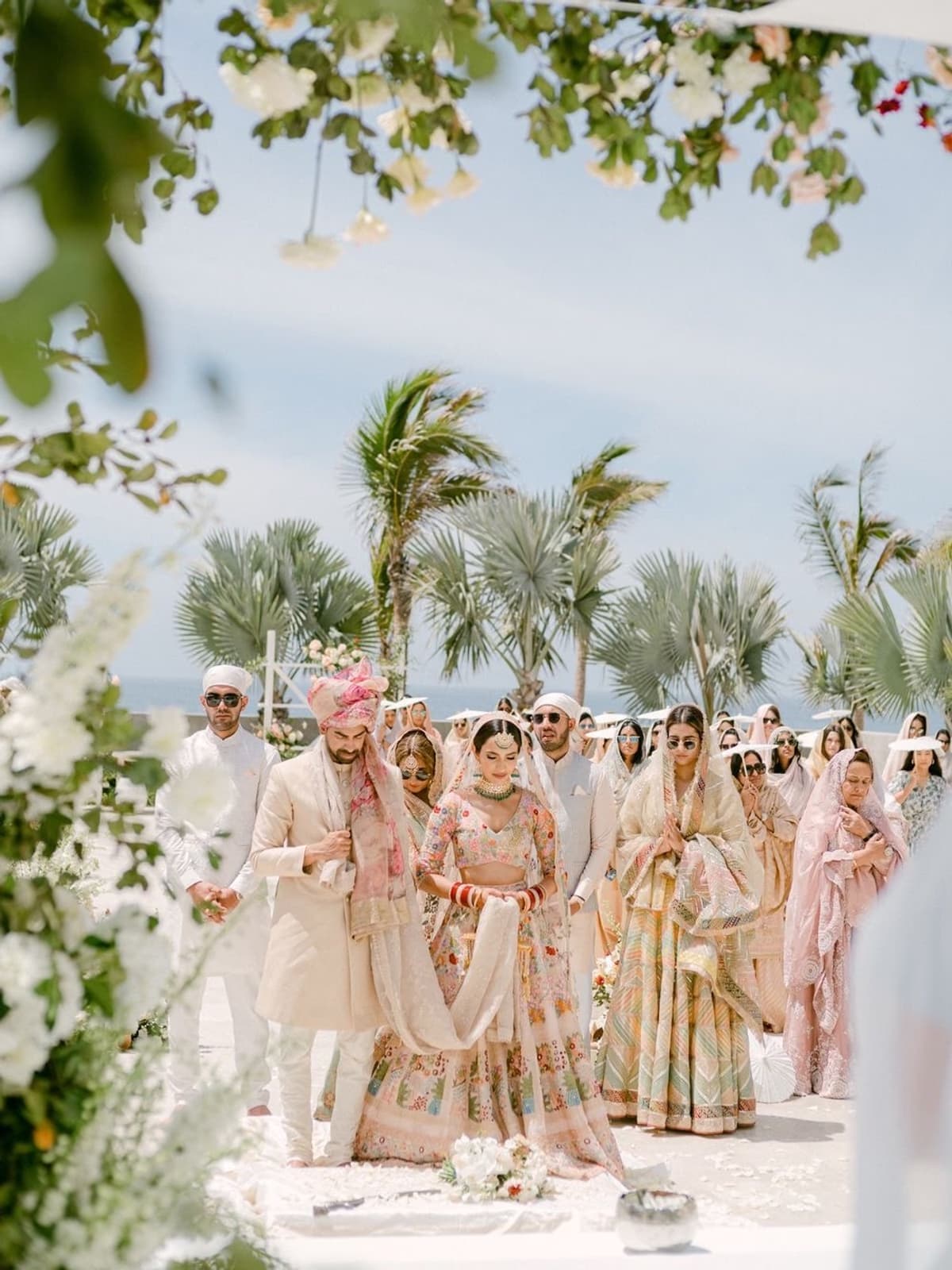 Indian bride and family walking the aisle at a beach wedding ceremony, destination bridal makeup by Elani Artistry