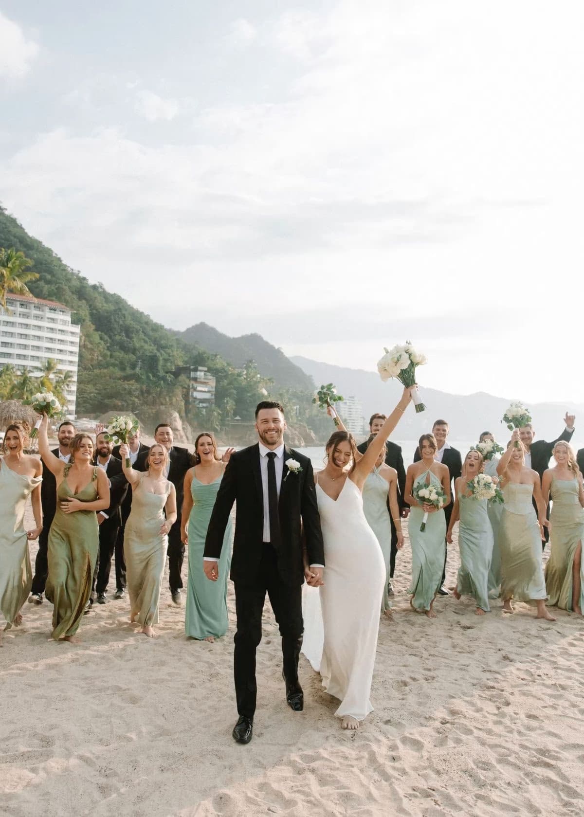 Bride and groom with wedding party celebrating on the beach at a destination wedding, Elani Artistry bridal makeup