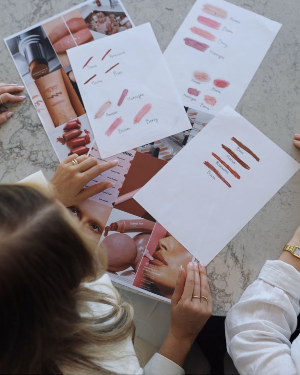 Makeup swatch planning sheets and product references laid out during a personal makeup shopping session with Elani in Dubai