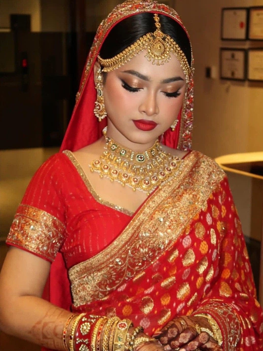 Bengali bride in Dubai in white and red Benarasi saree with shakha pola and traditional refined bridal makeup by Elani Artistry